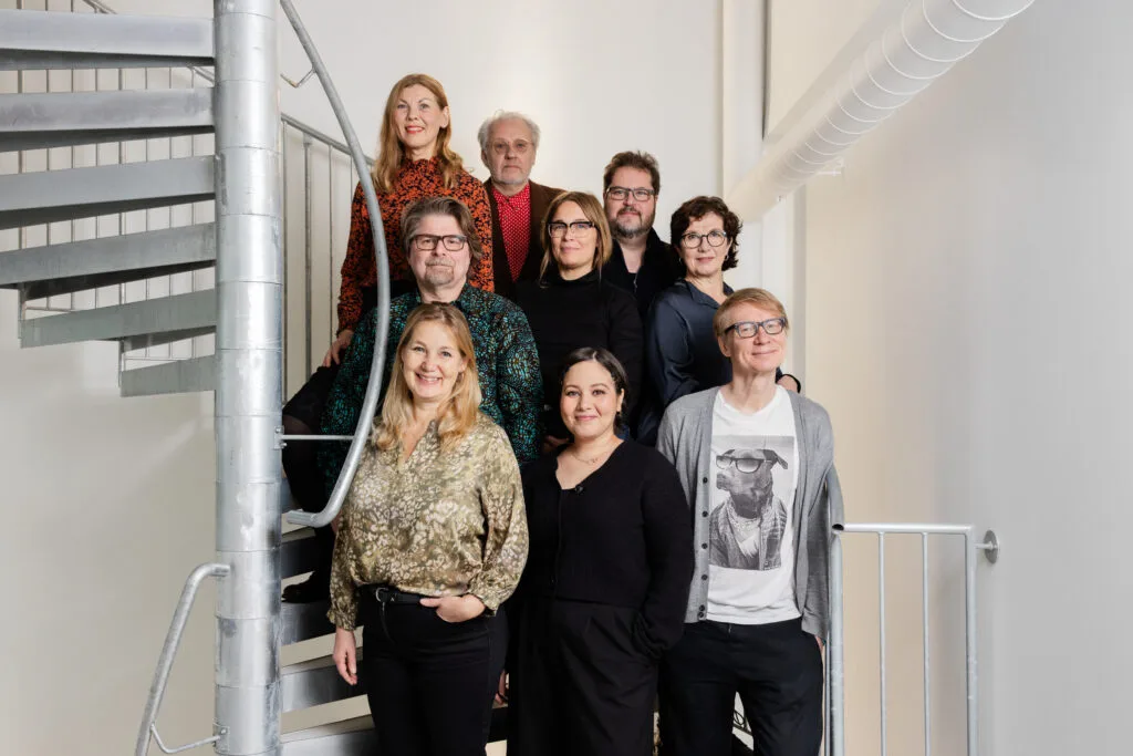 Asiantuntijatoimikunnan yhdeksän jäsentä seisovat kuvassa yhdessä.